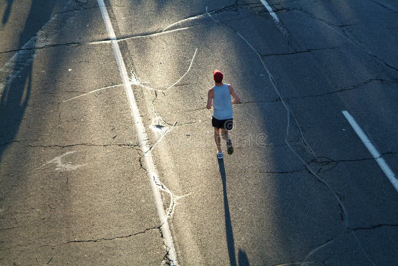 Solitario maratón corredor cabeza k ascendiendo el sol durante partir de progreso de la raza.