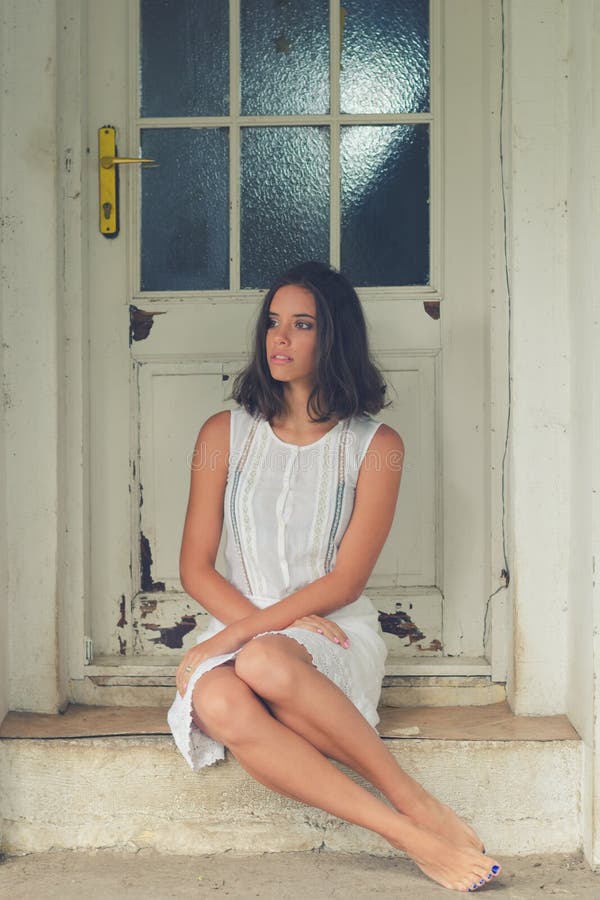 Lonely Sad Barefoot Girl Sitting in Front of the House in Spring Stock