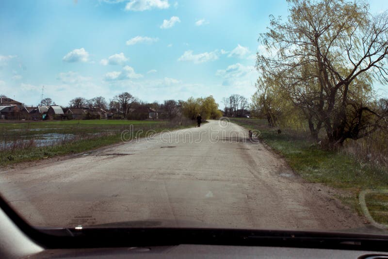 A lonely silhouette of a man in black is visible in the distance on the side of the road royalty free stock photo