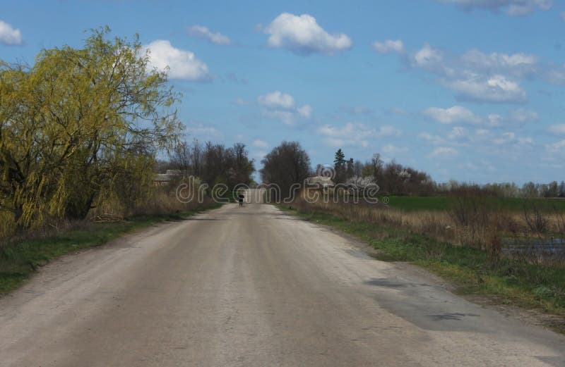 A lonely silhouette of a man in black is visible in the distance on the side of the road royalty free stock photos