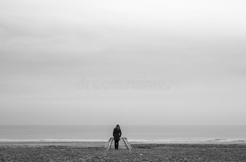 Lonely woman in red dress in wooden pier at the beach with calm sea royalty free stock image Lonely woman in red dress in wooden pier at the beach with calm sea royalty free stock image
