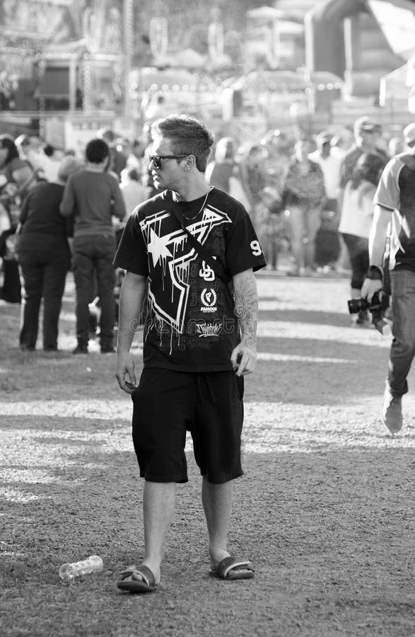 Lonely young teen man standing out from the crowd at carnival