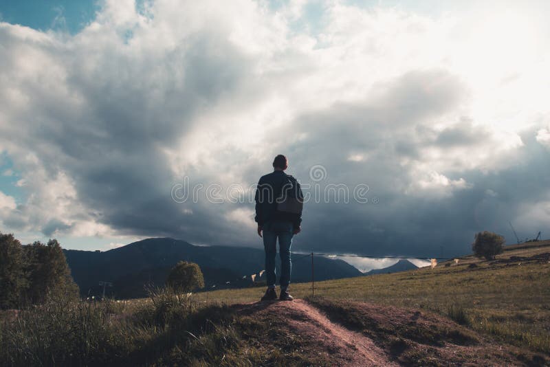 Osamělý mladý turista s batohem vylezl na vrchol a hle