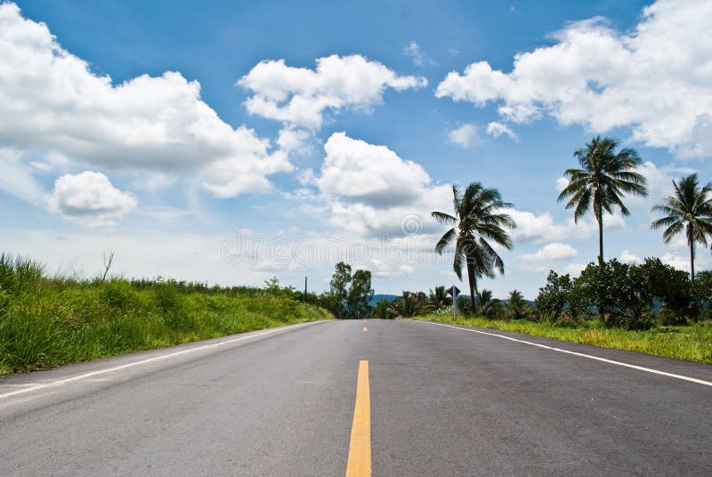 Long asphalt road with the blue sky.