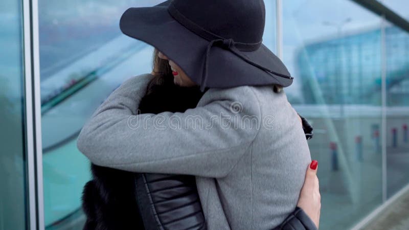 Long-awaited meeting of two friends at the airport. Slow motion