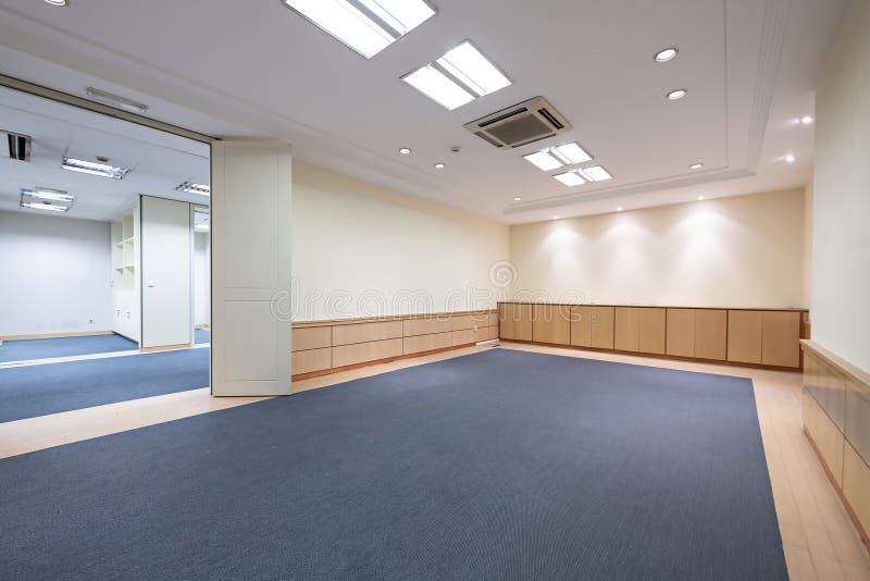 A Long Empty Office Hallway with Mixed Blue Carpet and Light Wooden