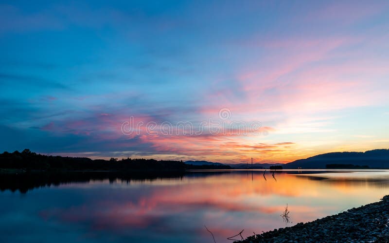 Long exposure landscape photography of sunset reflecting on water surface.