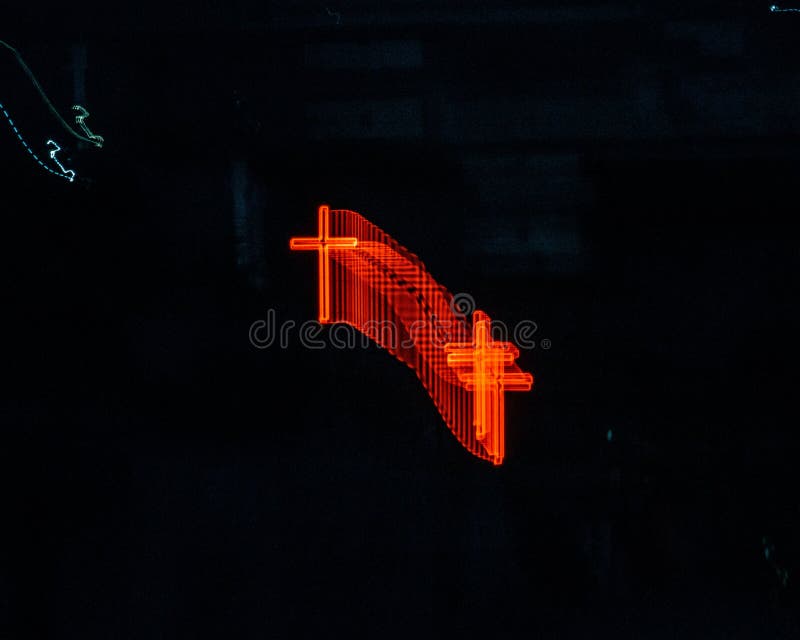 Long Exposure Shot of a Red Neon Cross Isolated on an Empty Black