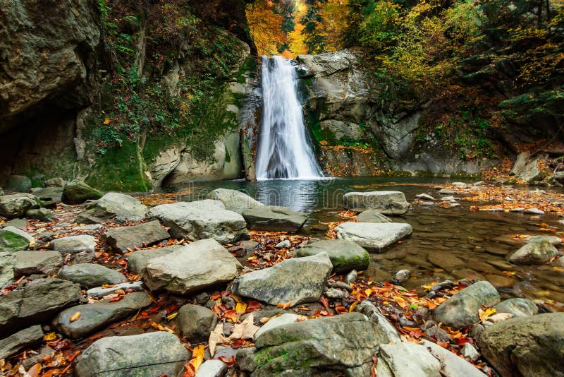 Long exposure view of the beautiful Prunceaâ€“CaÅŸoca Waterfall with fallen leaves in an autumn landscape