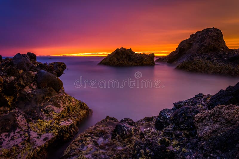 Long exposure of waves and rocks in the Pacific Ocean at sunset