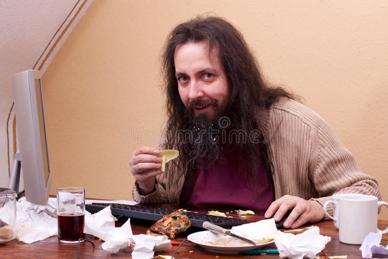 Long haired unkempt man sitting at the computer