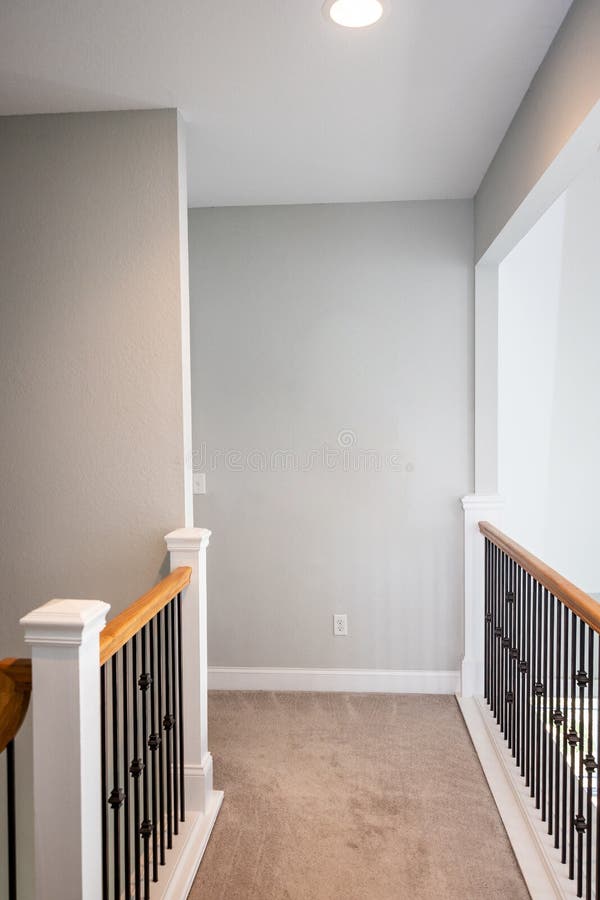 A Long Hallway Upper Level Balcony with Light Gray Modern Walls Stock