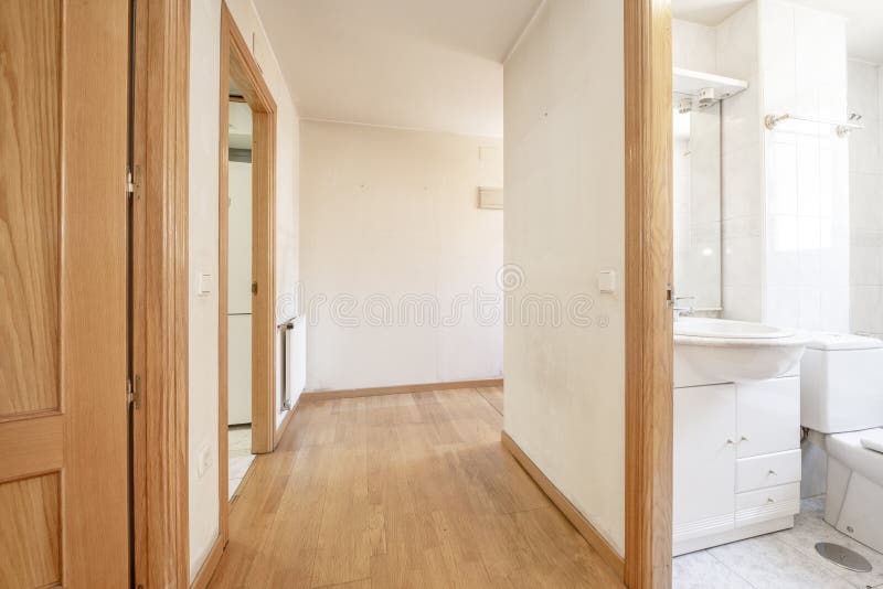 Long Narrow Hallway with Several Oak Doors and a Wooden Border Along