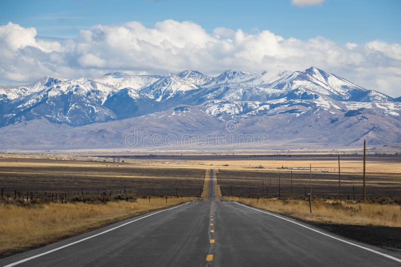 A Long, Straight Road Heading into the Distant Mountains Stock Photo