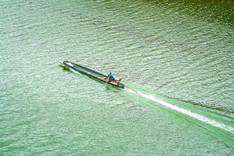 Long tail boat with fishing man sailing on the river , nature background top view. Close up Long tail boat with fishing man sailing on the river , nature royalty free stock image Long tail boat with fishing man sailing on the river , nature background top view. Close up Long tail boat with fishing man sailing on the river , nature royalty free stock image
