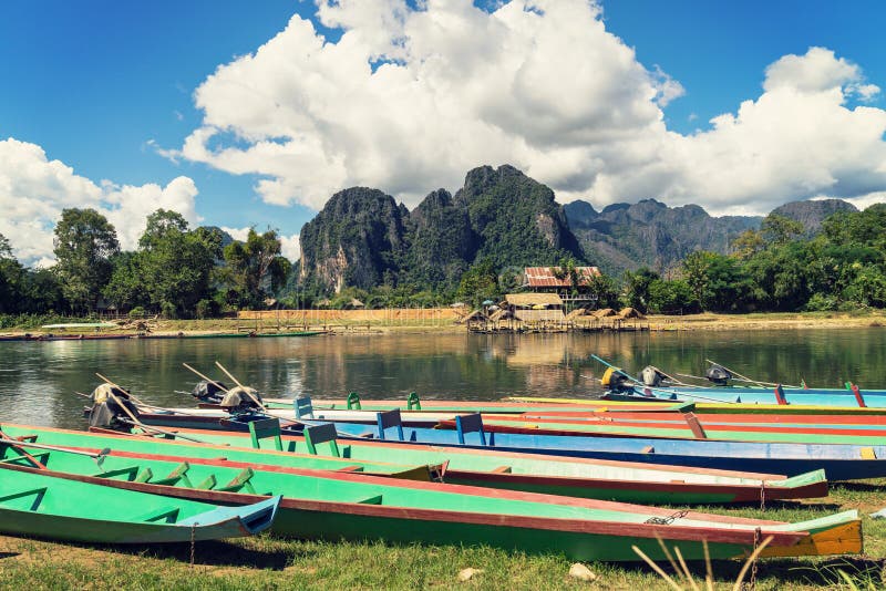 Long tail boats on sunset at Song river, Vang Vieng, Laos.