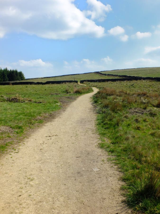 A long winding footpath running into the distance in stoodley moor in yorkshire with fields and farms in the distance stock photos A long winding footpath running into the distance in stoodley moor in yorkshire with fields and farms in the distance stock photos