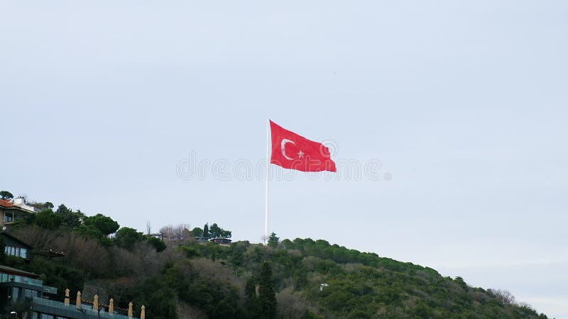 Longue photo du drapeau rouge national turc agitant au vent sur la colline