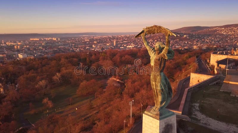 Longueur aérienne de Budapest, Hongrie 4k au lever du soleil du drone volant autour de la statue de la liberté banque de vidéos