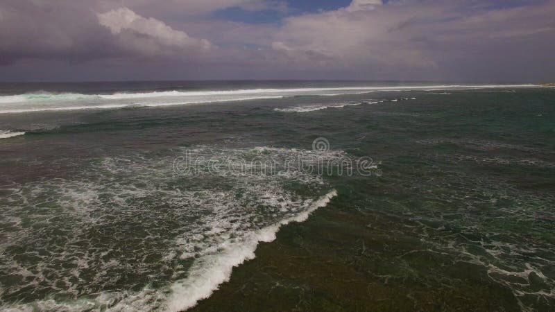 Longueur aérienne du bourdon 4k des ressacs se cassant avant le rivage Bali, Indonésie clips vidéos
