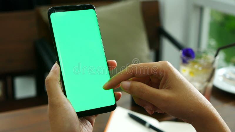 Longueur 4k main haute étroite de femme tenant la pierre à aiguiser intelligente avec l'écran vert au café, doigt de glissière su banque de vidéos