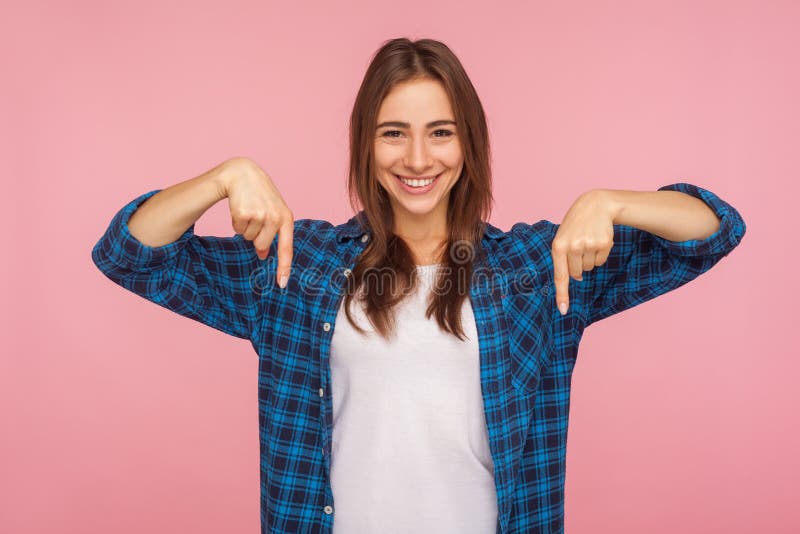 Look down, choose option below! Portrait of charming brunette girl in checkered shirt pointing down