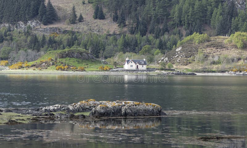 Looking across a Loch with boulders in the foreground stock image