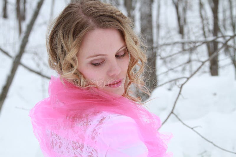 Portrait of an ethereal, beautiful young woman in a snowy forest looking back over her shoulder. Portrait of an ethereal, beautiful young woman in a snowy forest looking back over her shoulder.