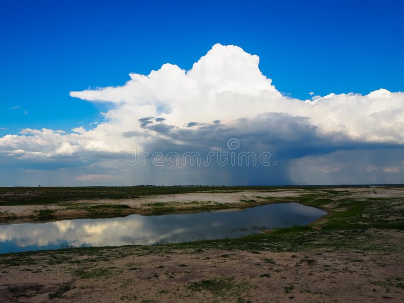 Looking at beautiful raining cloud from afar with blue sky background and water reflection during game drive in Chobe national park. Day game drive stock images, royalty-free photos and pictures