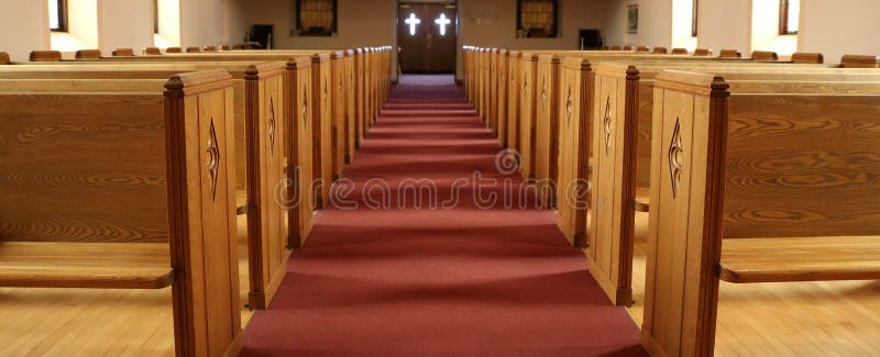 Aisle of traditional Christian church with empty pews