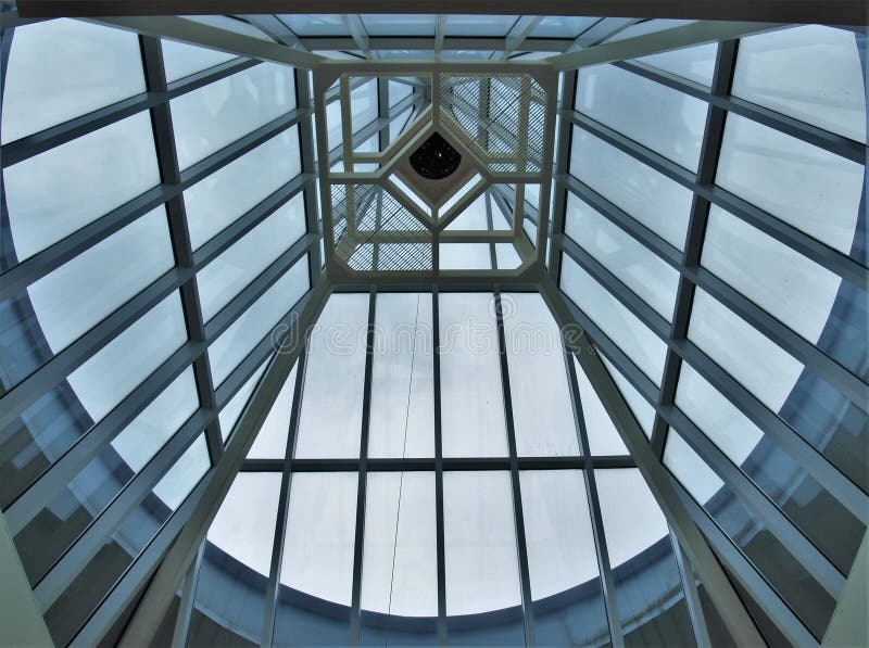 Looking at the Sky through Skylights. Glass and steel skylights that extend above a modern building provide views of the blue sky stock photo Looking at the Sky through Skylights. Glass and steel skylights that extend above a modern building provide views of the blue sky stock photo