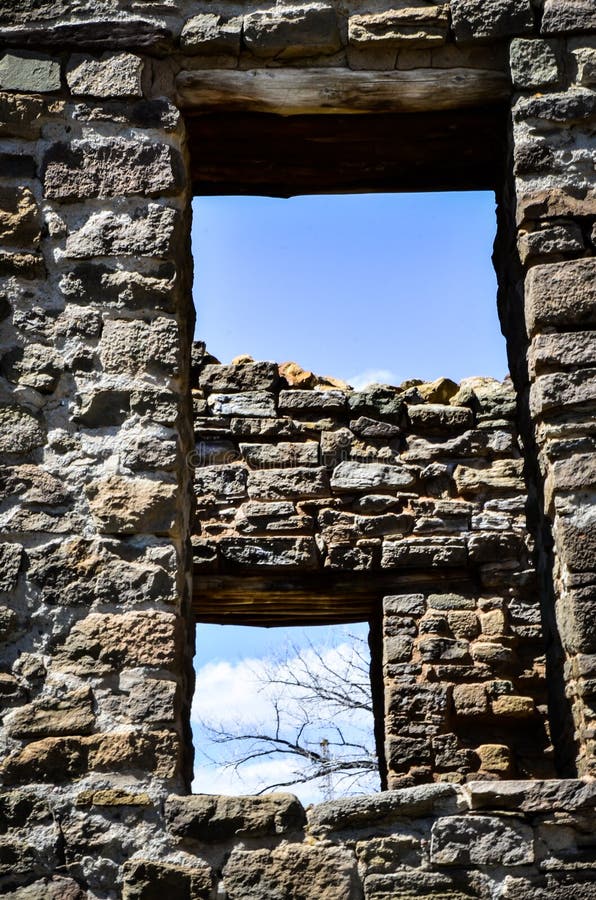 Looking Thru Ancient Windows at A Blue Sky with Bare Branches and Clouds