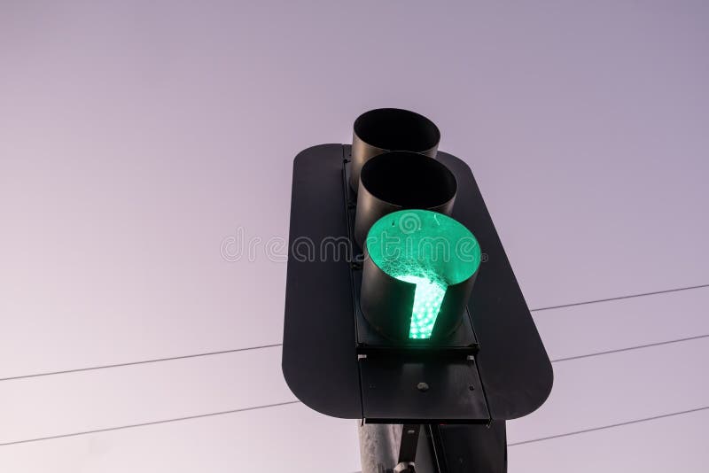 Looking up at green traffic light against the sky at sunset. royalty free stock photography