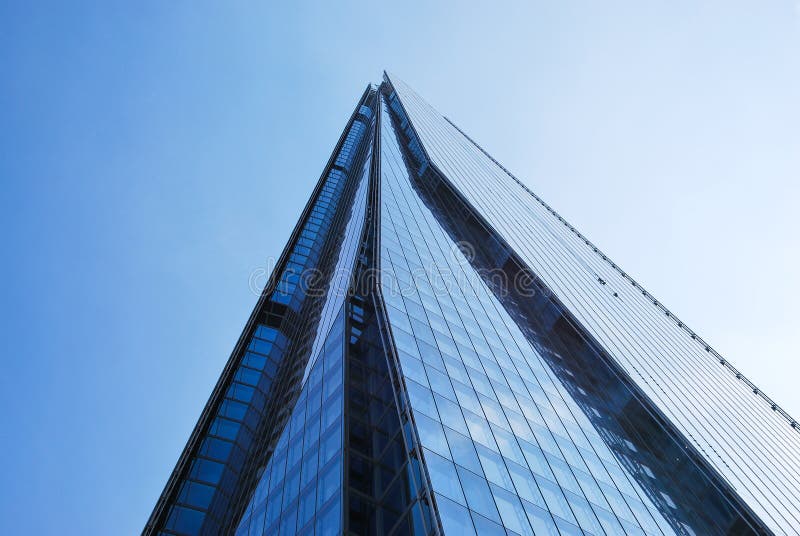 Looking up at the Shard skyscraper against blue sky.