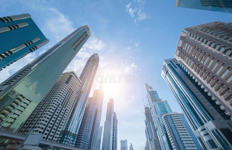 Looking up to high-rise office buildings, skyscrapers, architectures in financial district with blue sky. Smart urban city for