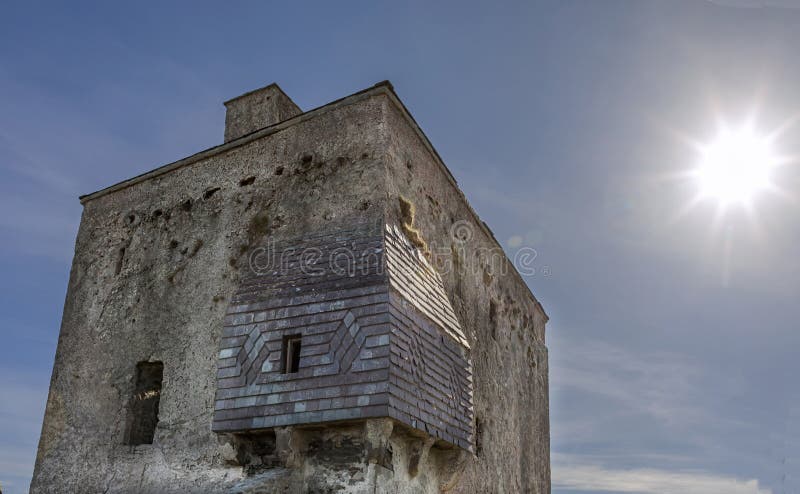 Looking upwards towards the sun at a tall ornate tower stock photo