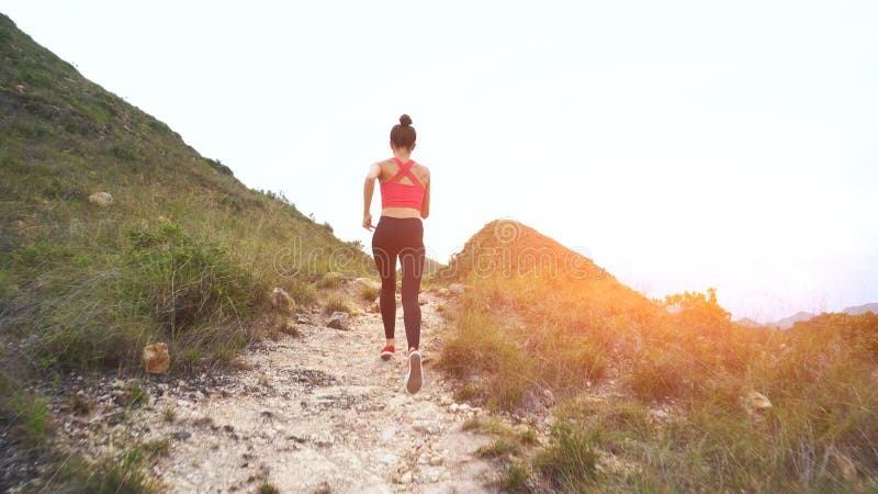 Lopende vrouw op bergweg Sportmeisje die buiten in bergen uitoefenen royalty-vrije stock afbeeldingen Lopende vrouw op bergweg Sportmeisje die buiten in bergen uitoefenen royalty-vrije stock afbeeldingen