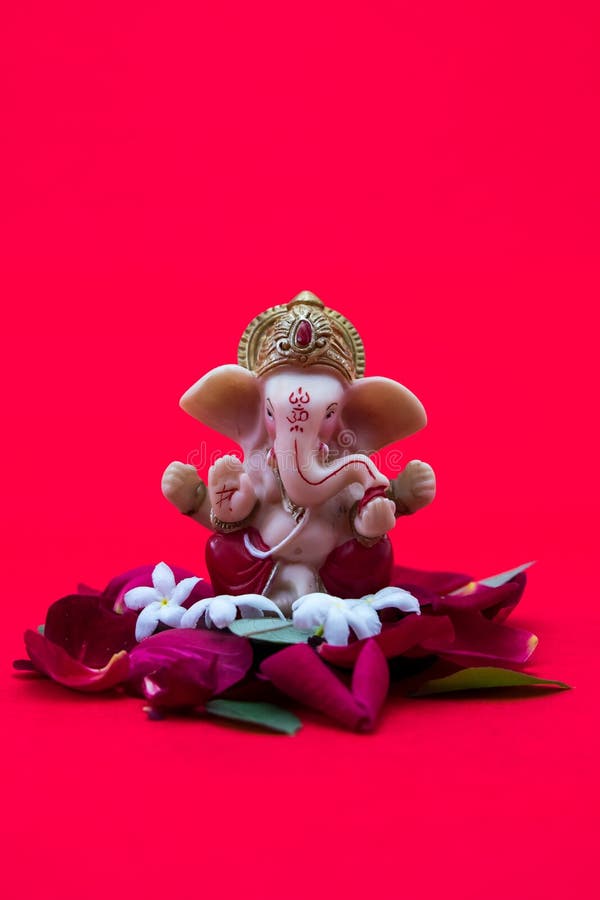 Lord Ganesha Idol with Rose Petals on Red Background, Ganesha Chautrhi ...