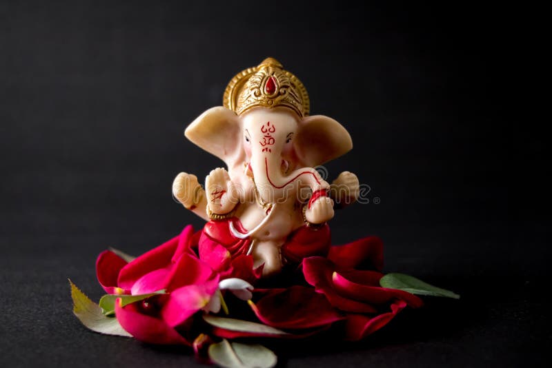 Lord Ganesha Idol with Rose Petals, White Flowers and Leaves on Black ...