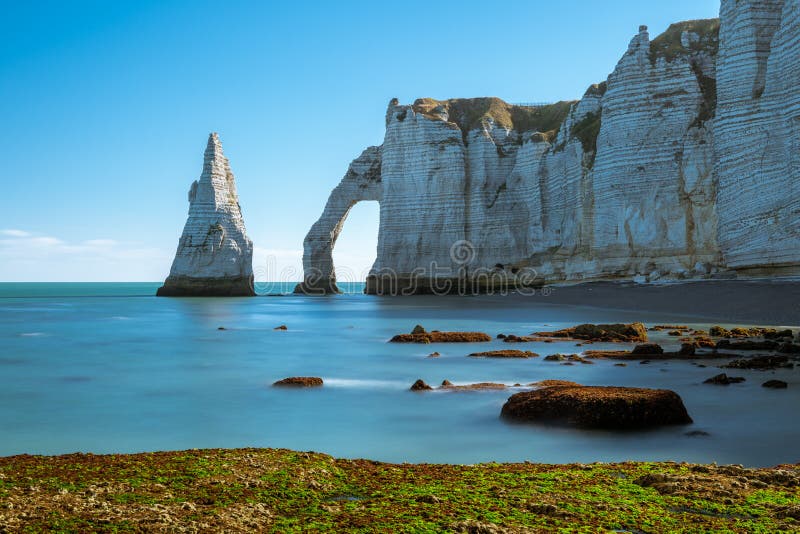 Los acantilados de tiza de Etretat con el ` natural Aval de Porte d del arco y la aguja de piedra llamaron L ` Aiguille imagenes de archivo Los acantilados de tiza de Etretat con el ` natural Aval de Porte d del arco y la aguja de piedra llamaron L ` Aiguille imagenes de archivo