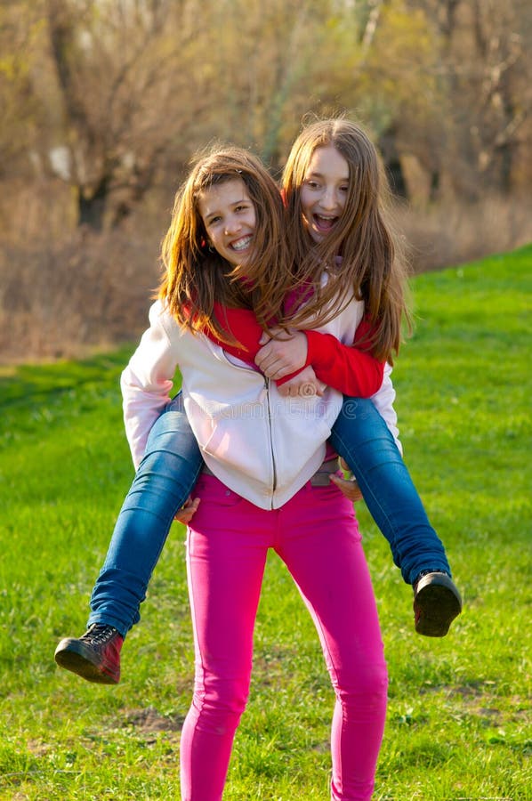 Los adolescentes felices llevan a cuestas el montar a caballo en prado fotos de archivo libres de regalías Los adolescentes felices llevan a cuestas el montar a caballo en prado fotos de archivo libres de regalías