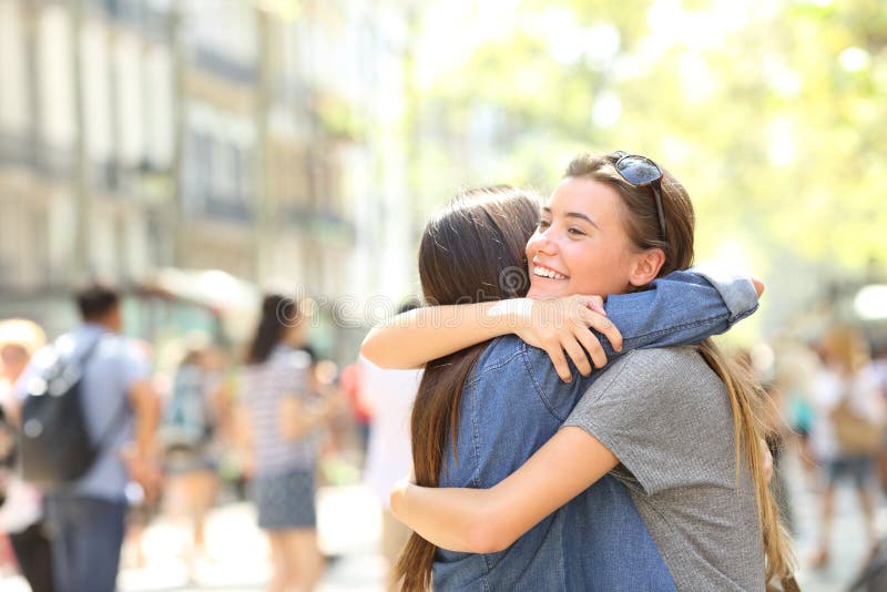 Los amigos abrazan en la calle