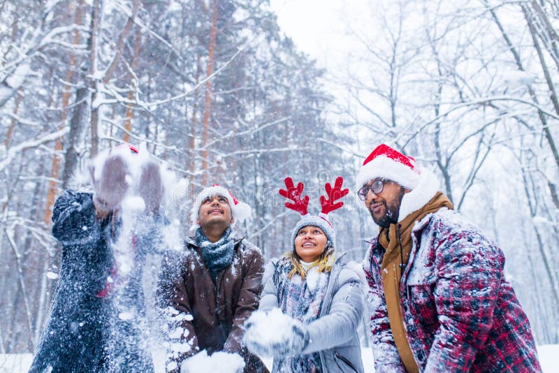 Los amigos felices se están divirtiendo y disfrutando de la primera nieve usando sombrero divertido y cuerno de ciervo fotos de archivo