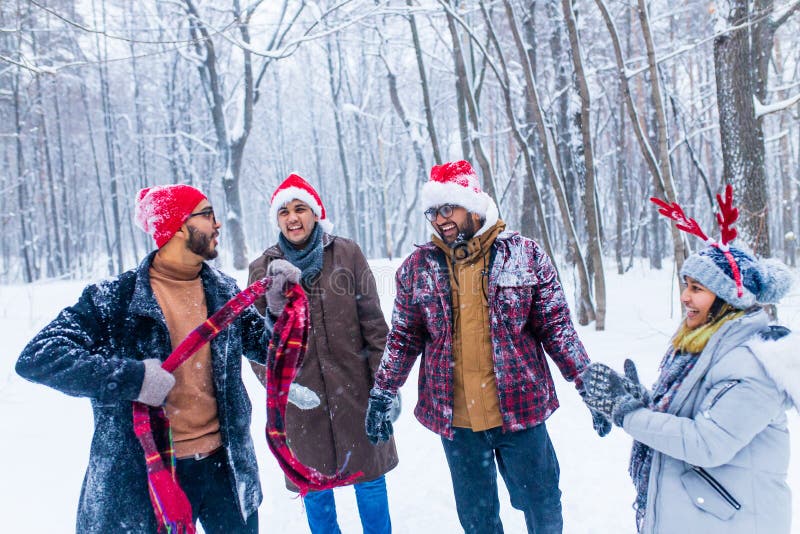 Los amigos felices se están divirtiendo y disfrutando de la primera nieve usando sombrero divertido y cuerno de ciervo foto de archivo