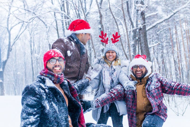 Los amigos felices se están divirtiendo y disfrutando de la primera nieve usando sombrero divertido y cuerno de ciervo imagen de archivo libre de regalías