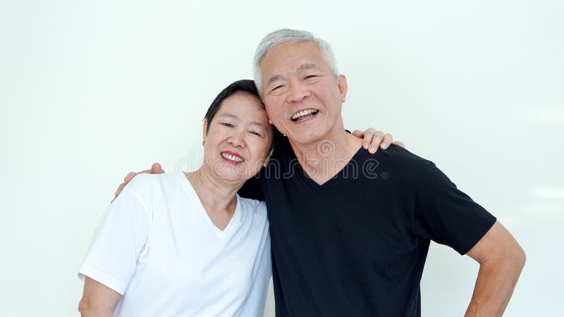 Los ancianos asiáticos brillantes, positivos y felices casaron a la pareja en blanco fotografía de archivo Los ancianos asiáticos brillantes, positivos y felices casaron a la pareja en blanco fotografía de archivo