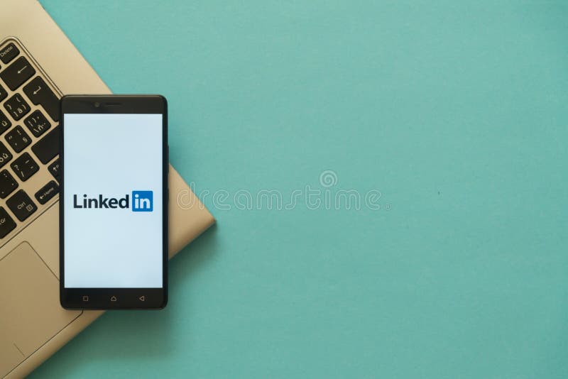 Linkedin logo on smartphone placed on laptop keyboard.