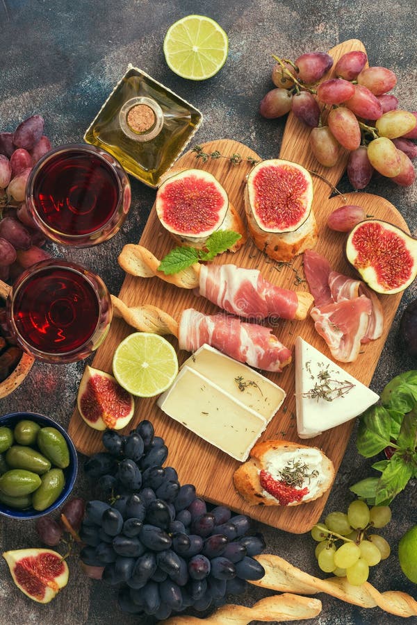 Los aperitivos presentan con bocados y vino italianos de los antipasti en vidrios Grissini tradicional de las barras de pan itali fotos de archivo libres de regalías Los aperitivos presentan con bocados y vino italianos de los antipasti en vidrios Grissini tradicional de las barras de pan itali fotos de archivo libres de regalías