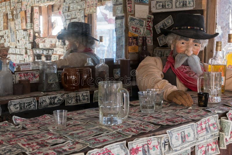 Old West saloon is adorned with dollar bills and an old cowboy at the bar. Old West saloon is adorned with dollar bills and an old cowboy at the bar