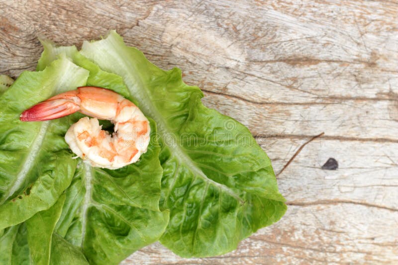 Los camarones con verde de las verduras se van en el fondo de madera imágenes de archivo libres de regalías Los camarones con verde de las verduras se van en el fondo de madera imágenes de archivo libres de regalías